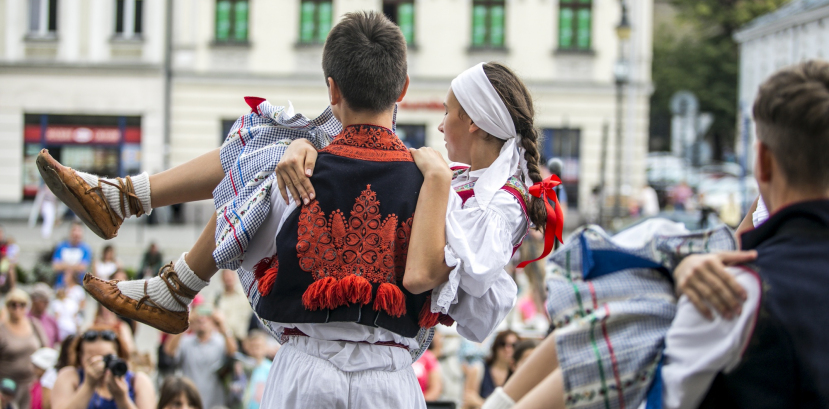 Chłopiec stoi tyłem, na rękach trzyma dziewczynę, w tle widać widzów