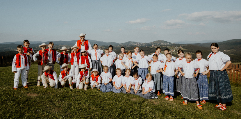 dzieci w strojach regionalnych na łące