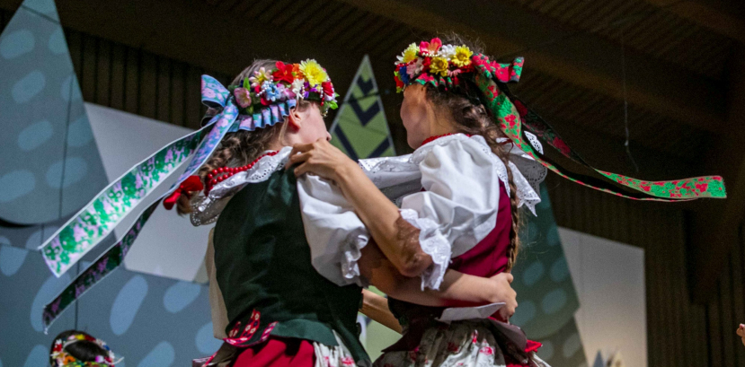 dzieci w strojach regionalnych tańczą na scenie