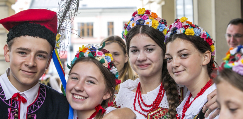 dzieci w regionalnych strojach obejmują się i uśmiechają