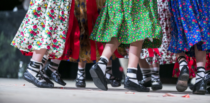 Nogi i regionalne spódnice dzieci tańczących na scenie