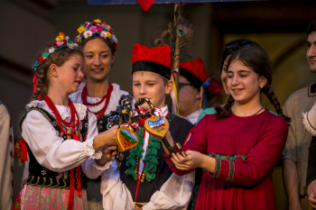 Chłopiec i dziewczynki w strojach ludowych na scenie