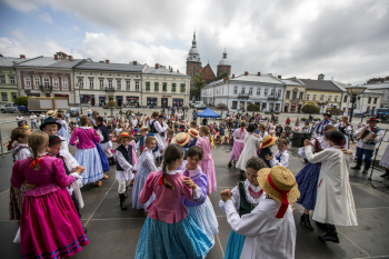 Dzieci w parach tańczą na płycie rynku.