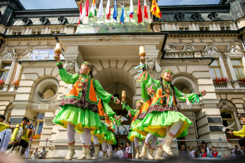 Dziewczynki w zielonych strojach tańczą przed ratuszem.