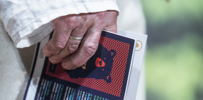 Opuszczona dłoń trzymająca folder festiwalu